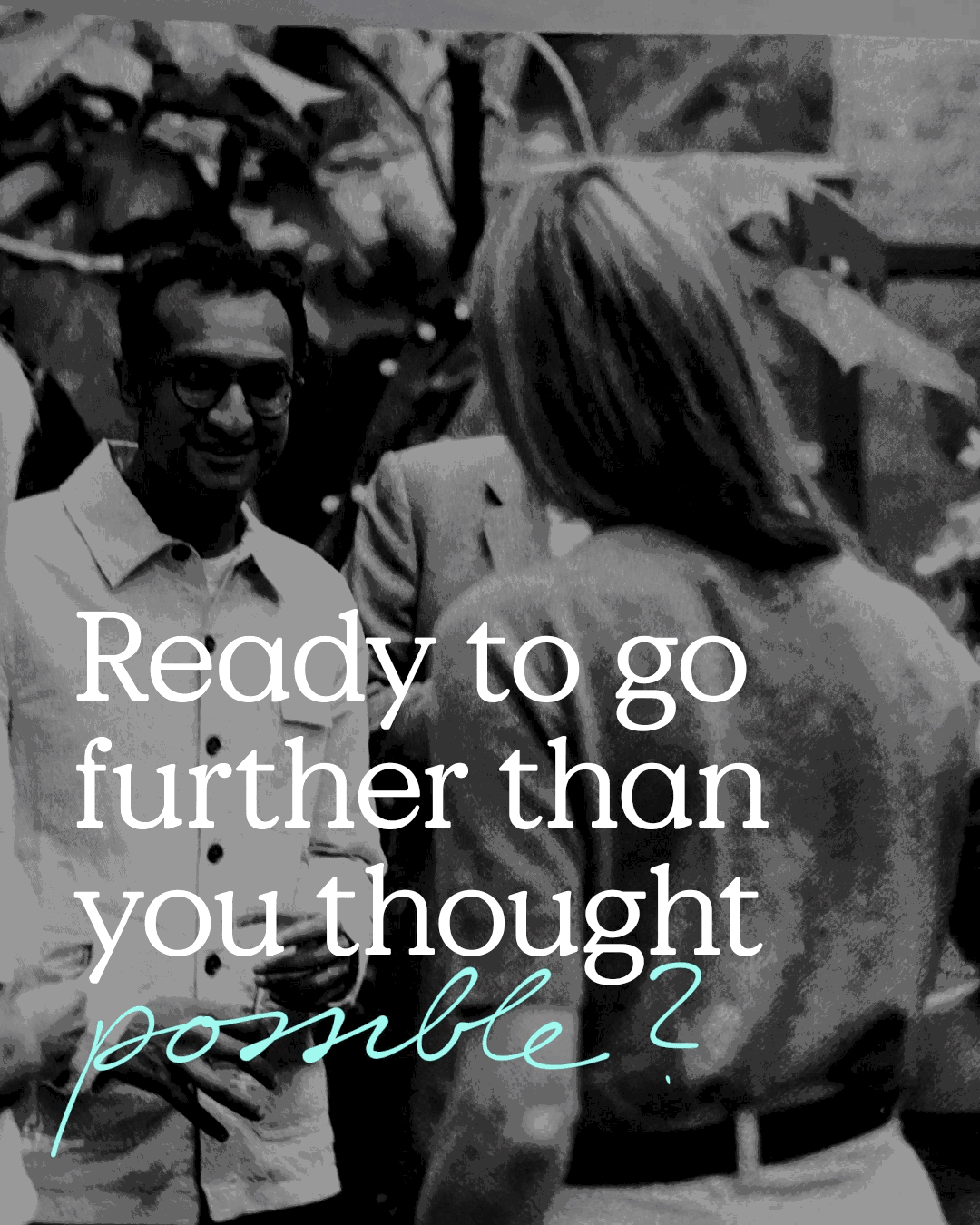 A man and a woman stand facing each other and talking, with greenery in the background. Overlaid text reads, Ready to go further than you thought possible?.