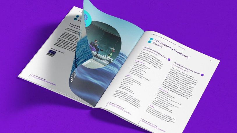 An open magazine on a purple surface shows pages with text, purple headings, and bullet points. One page features a circular image of a person working at a desk by a window, with a blue wave graphic across the spread.