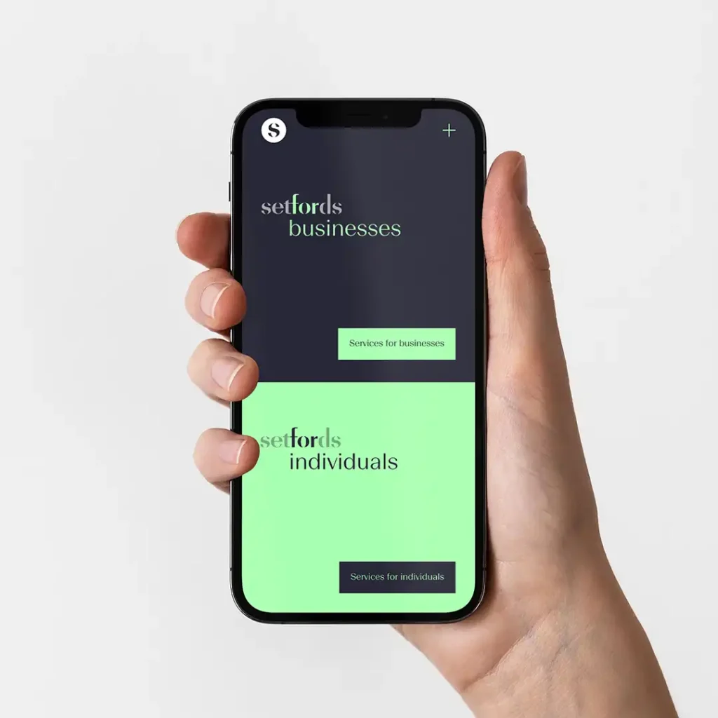 A hand holding a mobile phone displaying a website with two sections: setfords businesses and setfords individuals, each with a corresponding button for services on a green and dark background.