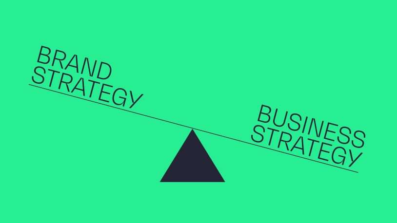 A simple seesaw illustration with Brand Strategy on the left and Business Strategy on the right, both balancing on a black triangle, mirrors how you brand a balance sheet—all set against a green background.