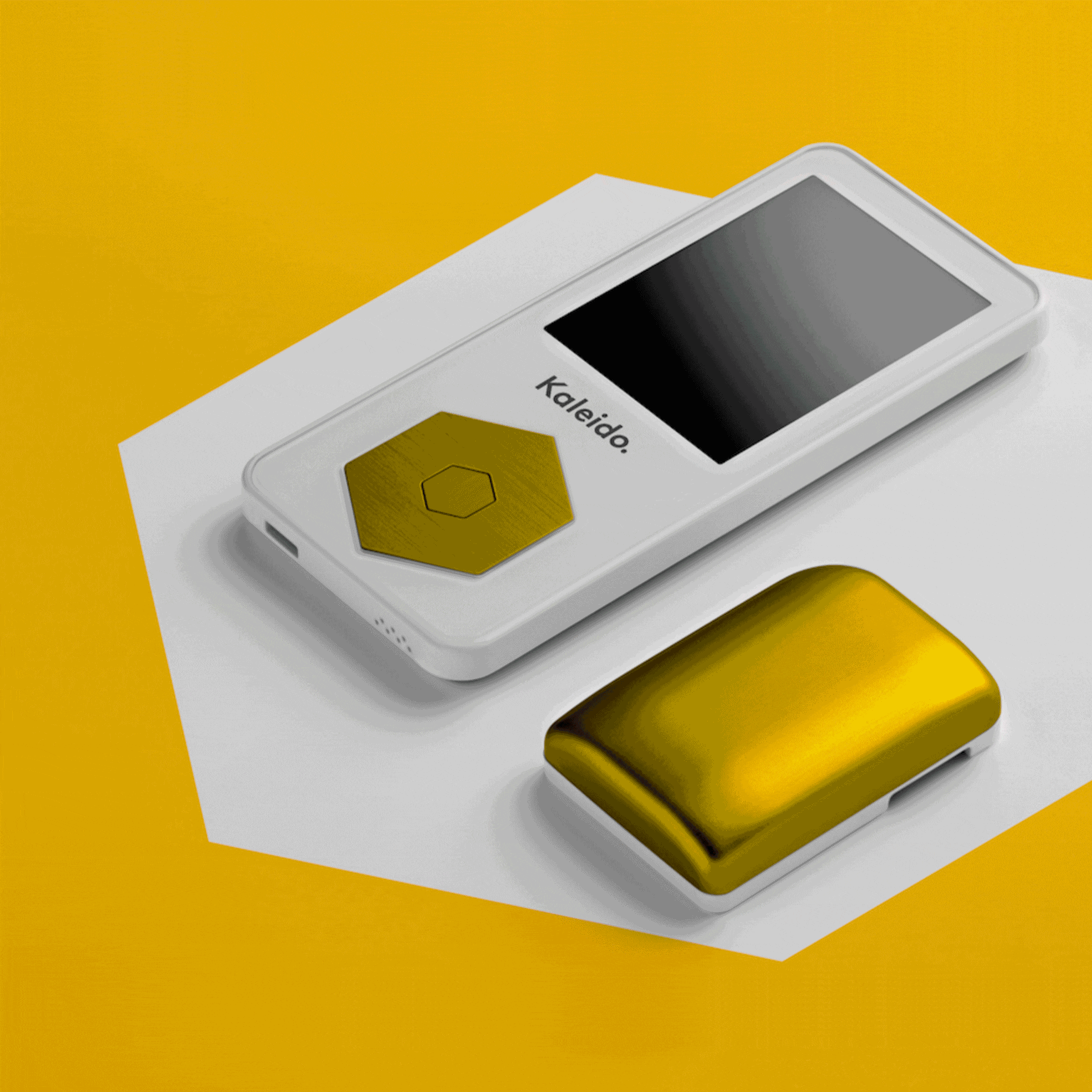 A white handheld device labelled Kaleido with a gold hexagonal button beside a shiny gold case, both resting on a white geometric surface against a yellow background.